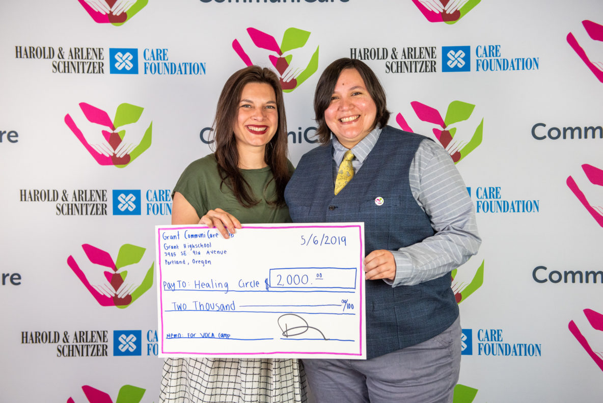 Two nonprofit representative receiving their grant check at award ceremony.